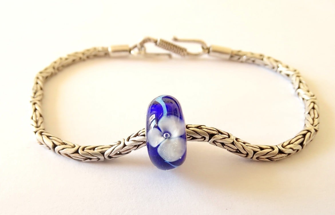 Handgemaakte donkerblauwe lampwork glasbedel met parelmoeren bloemen