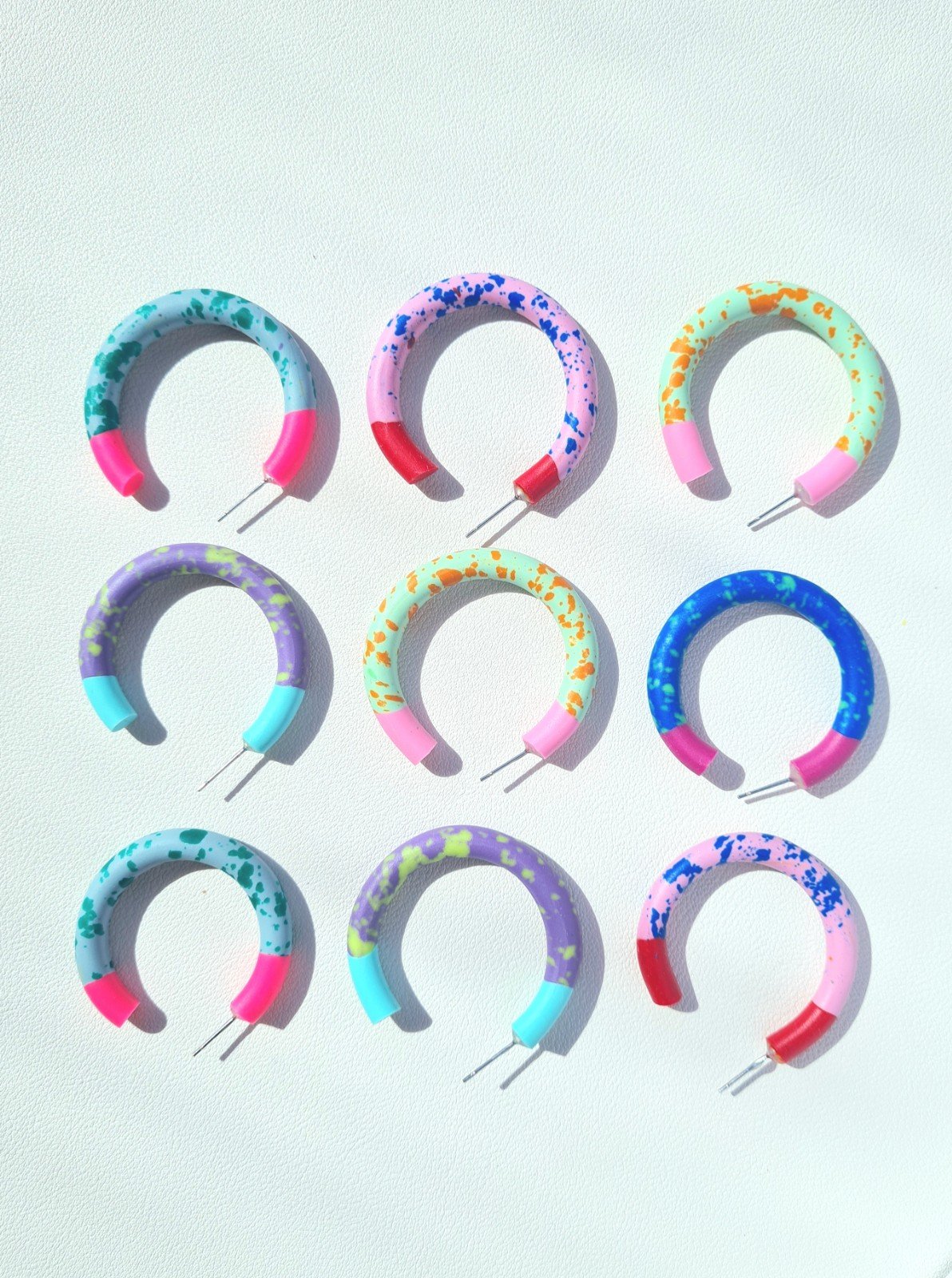 handgemaakte gespikkelde hoepeloorbellen uit polymeer klei in verschillende kleurencombinaties