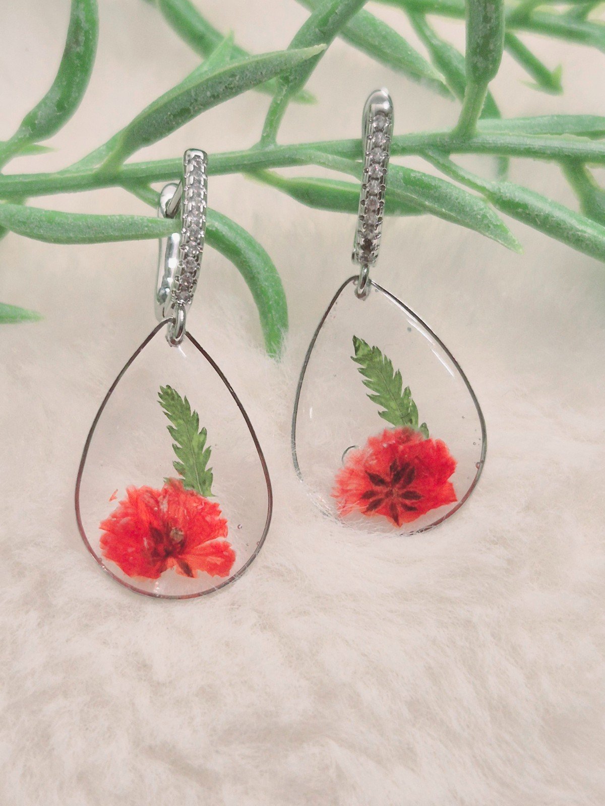 Resing Oorbellen - 47536.jpeg Voor een feestje of ergens anders mooie zilver waterdruppel vormige , met rode gedroogde bloemen resin oorbellen