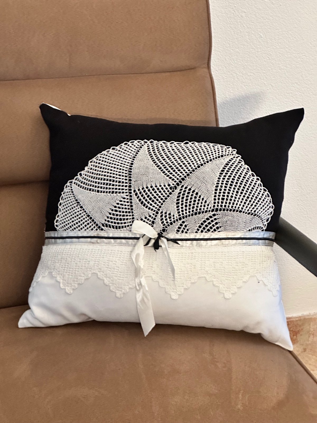 Zwarte kussenhoes bewerkt met gehaakt kant en tule