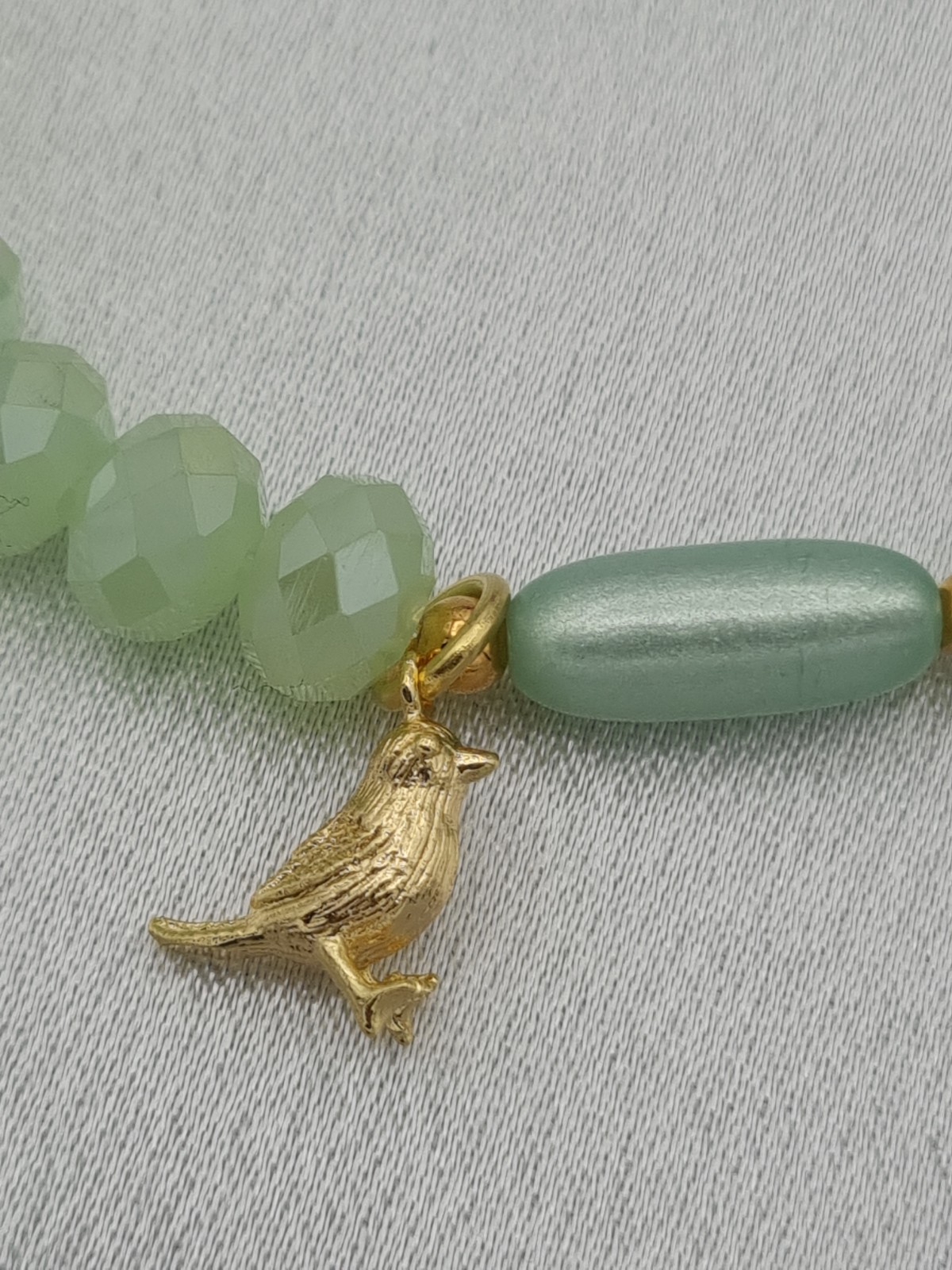 Handgemaakte armband met vergulde bedel