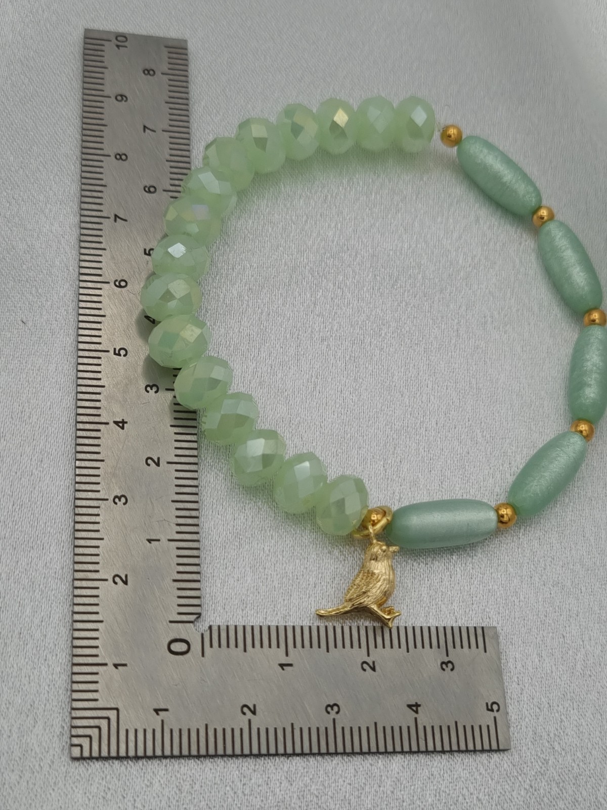 Handgemaakte armband met vergulde bedel