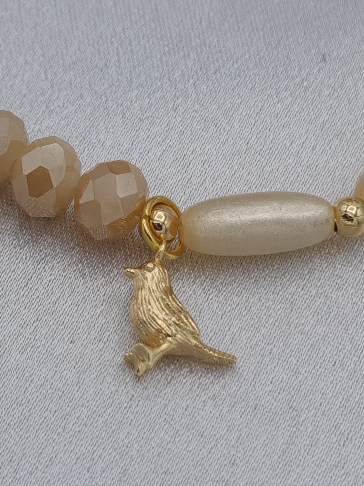 Handgemaakte armband met vergulde bedel - beige