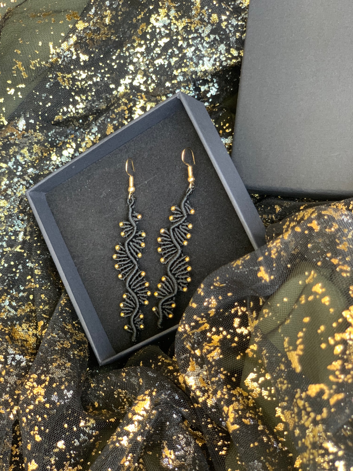 Zwarte macramé oorbellen met gouden accenten