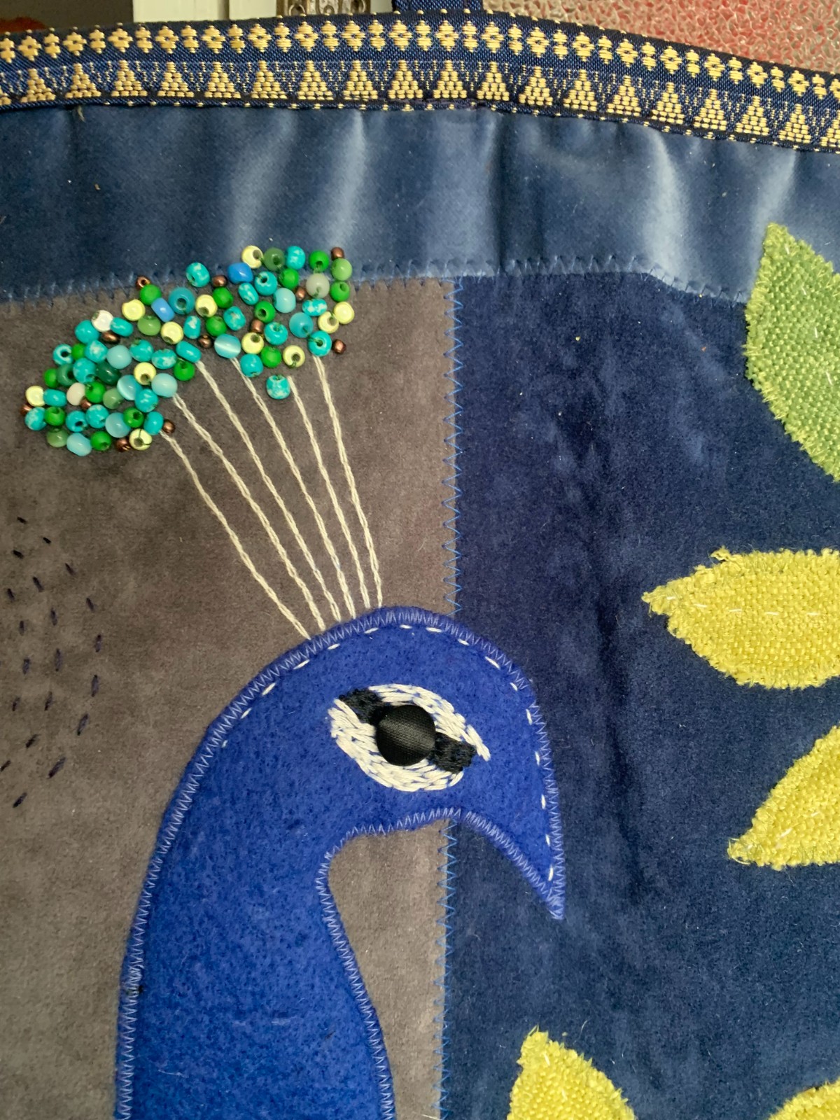 Mooi wandkleed van hergebruikte stoffen met een pauw