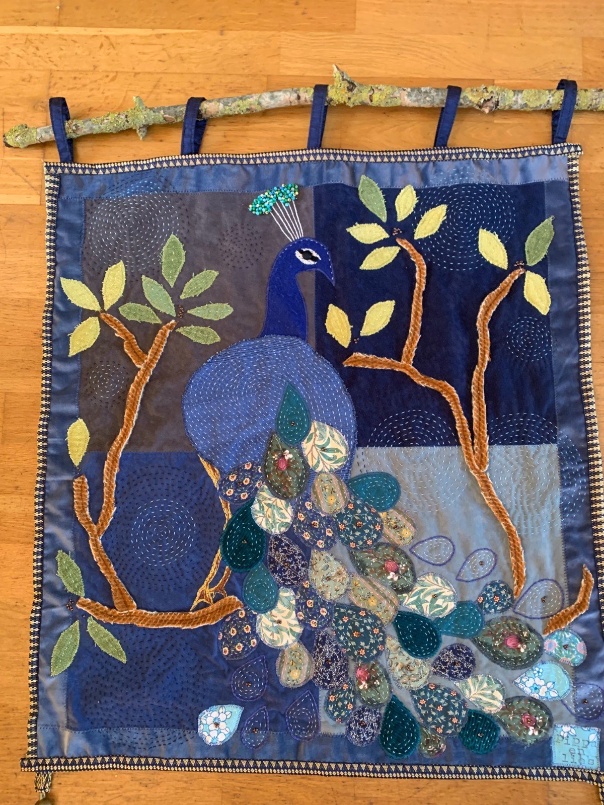 Mooi wandkleed van hergebruikte stoffen met een pauw