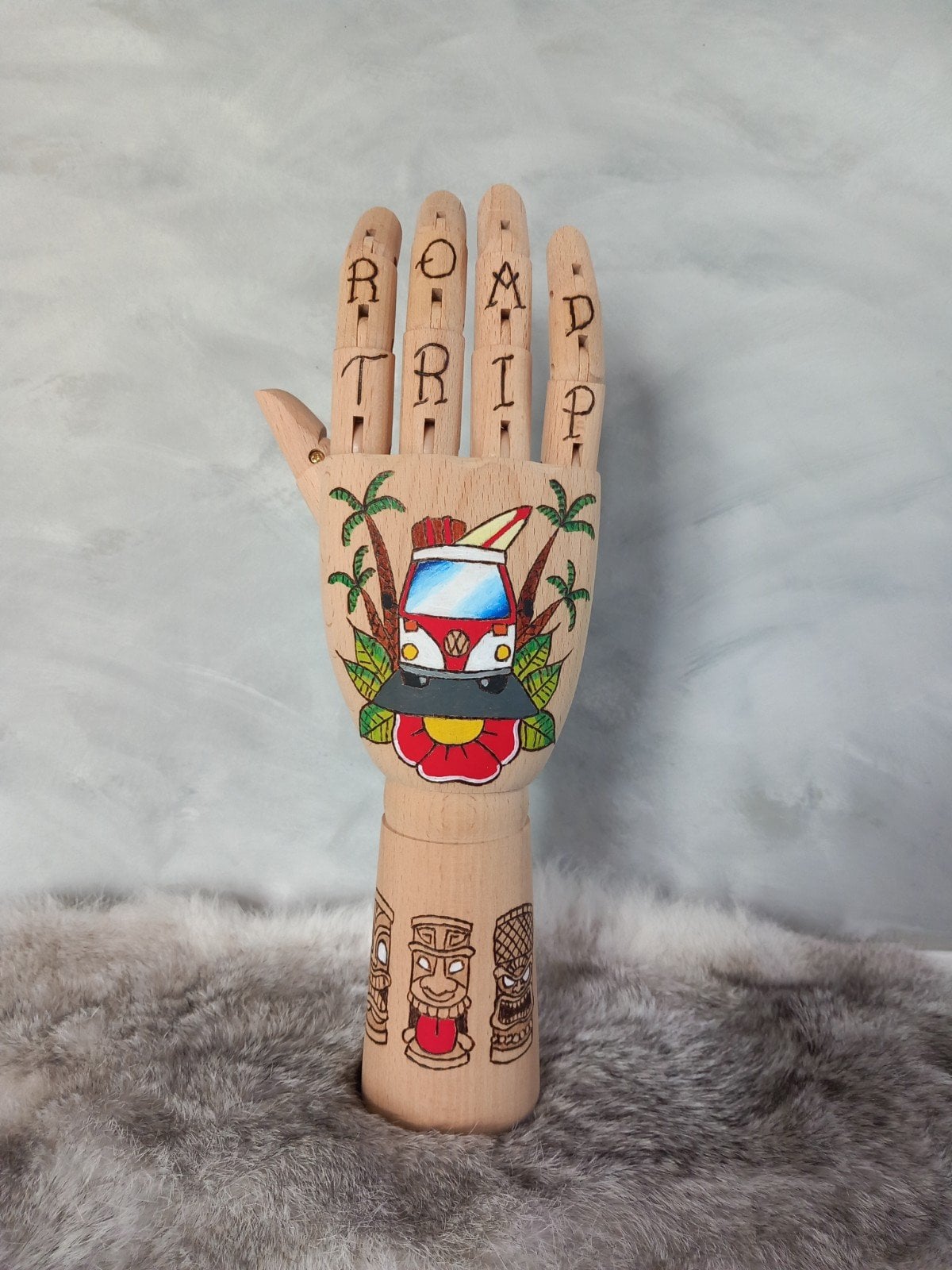 Houten Handje – rode volkswagen busje met palmbomen en tiki standbeelden