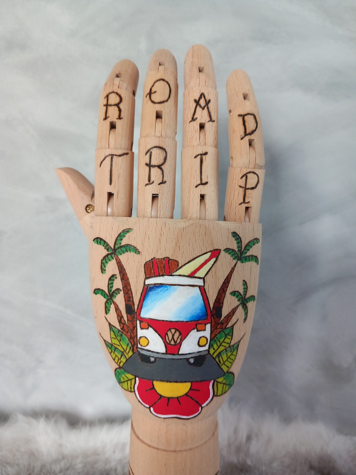 Houten Handje – rode volkswagen busje met palmbomen en tiki standbeelden