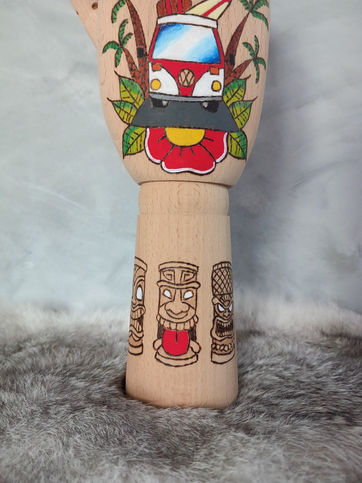 Houten Handje – rode volkswagen busje met palmbomen en tiki standbeelden