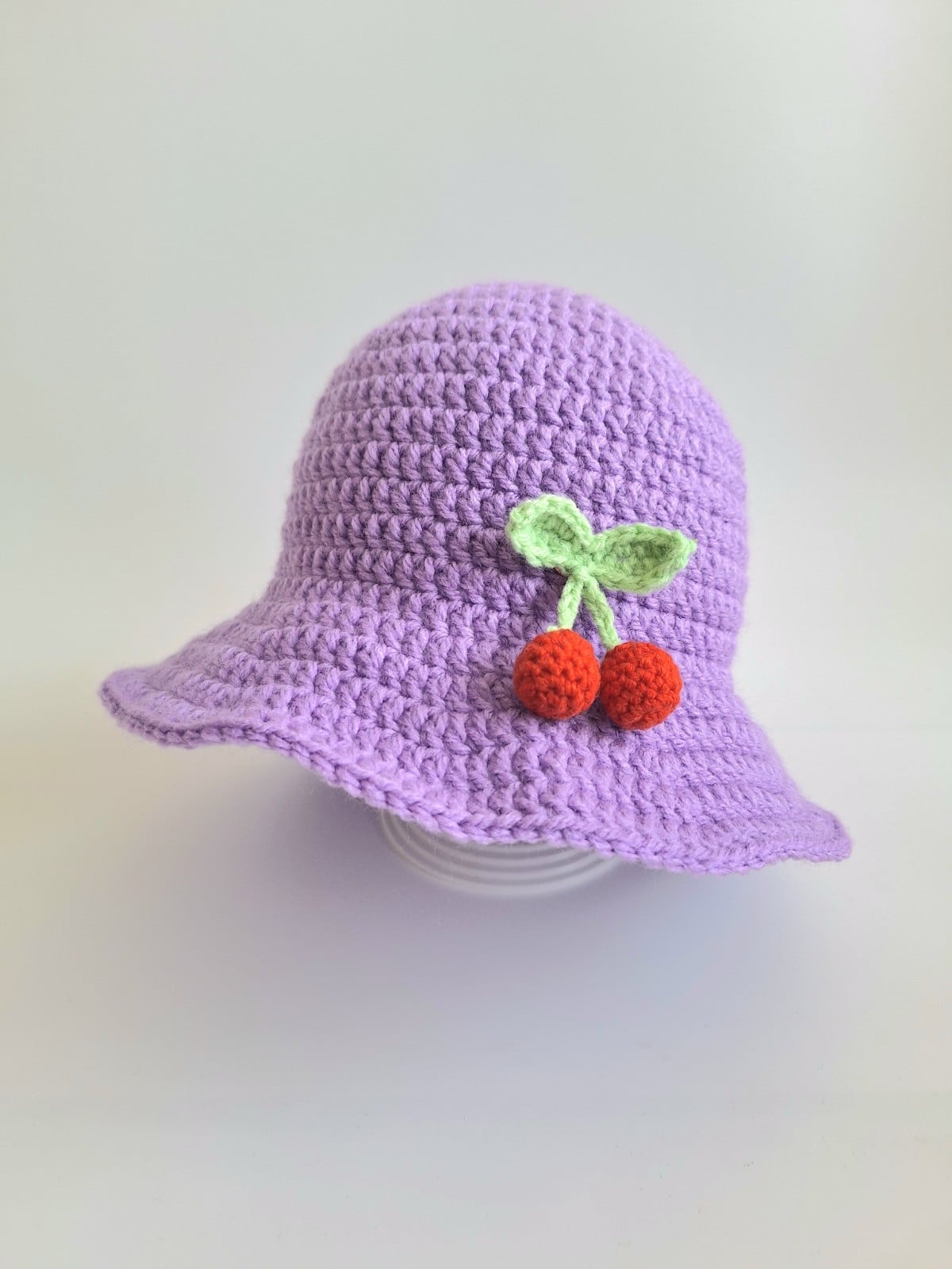 Gehaakte baby hoedje twee-in-een | Lila met kersjes en oranje bloemetje