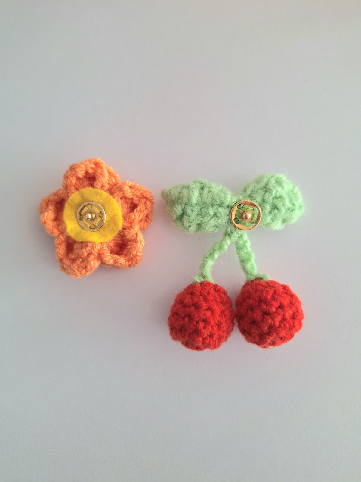 Gehaakte baby hoedje twee-in-een | Lila met kersjes en oranje bloemetje