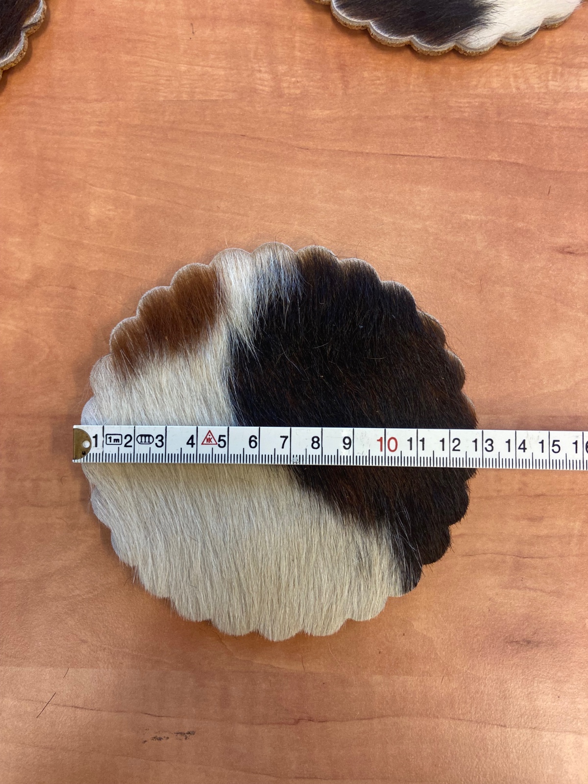 Handgemaakte onderzetters van koeienhuid 13 cm kartelrand.
