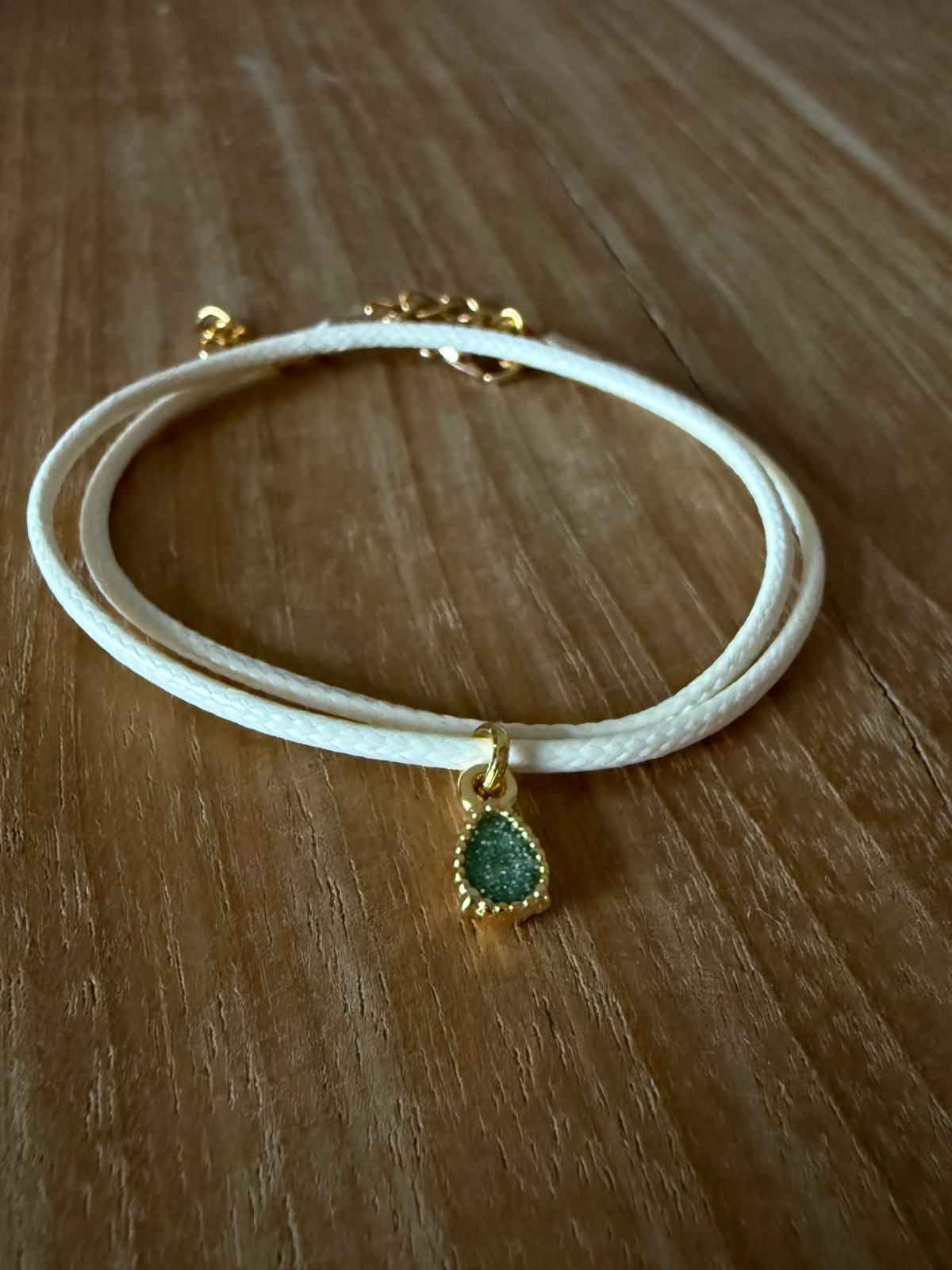 Stijlvol armbandje van crèmekleurig polyurethaan leer met een klein … - 155302 Stijlvol armbandje van crèmekleurig polyurethaan leer met een klein groen bedeltje.