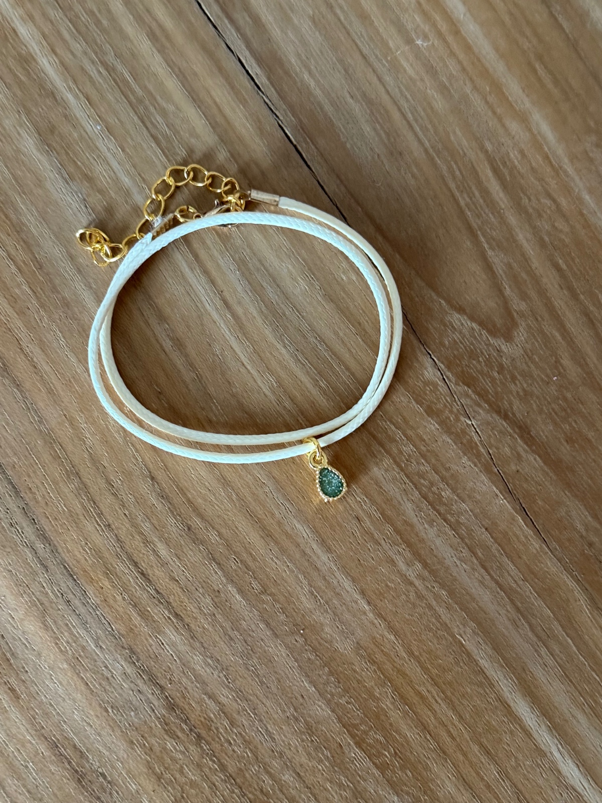 Stijlvol armbandje van crèmekleurig polyurethaan leer met een klein … - 155303 Stijlvol armbandje van crèmekleurig polyurethaan leer met een klein groen bedeltje.