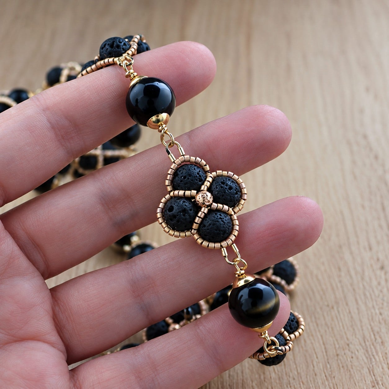 Zwarte Elegantie & Gouden Bloemen, handgeweven ketting met lavasteen en obsidiaan