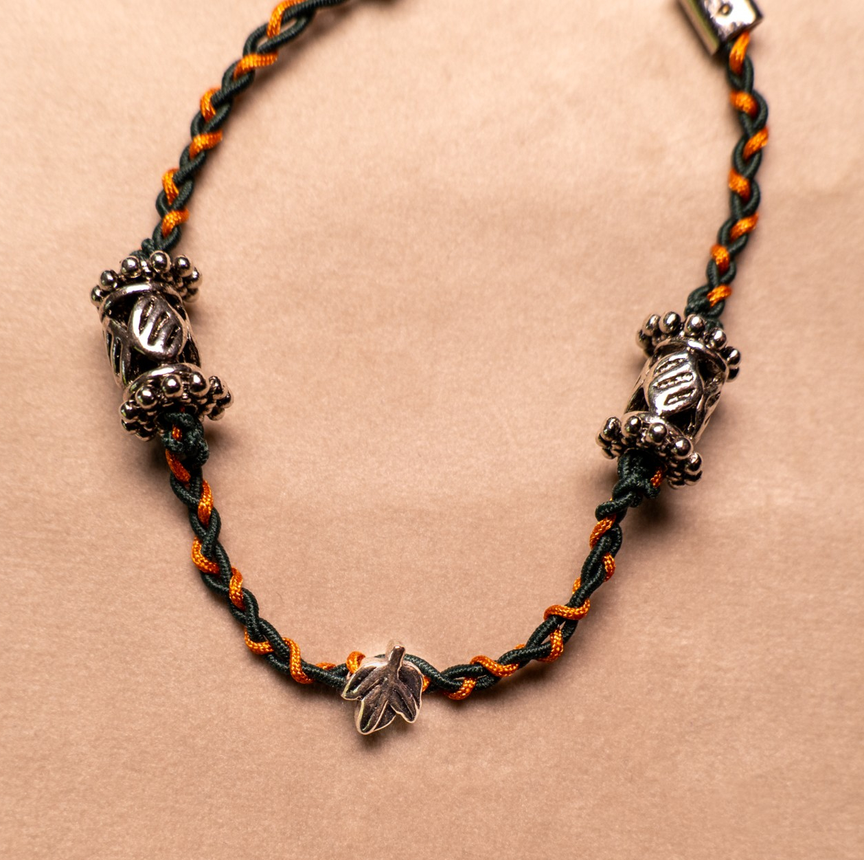 Gevlochten armband donkergroen en koperbruin met metalen kralen