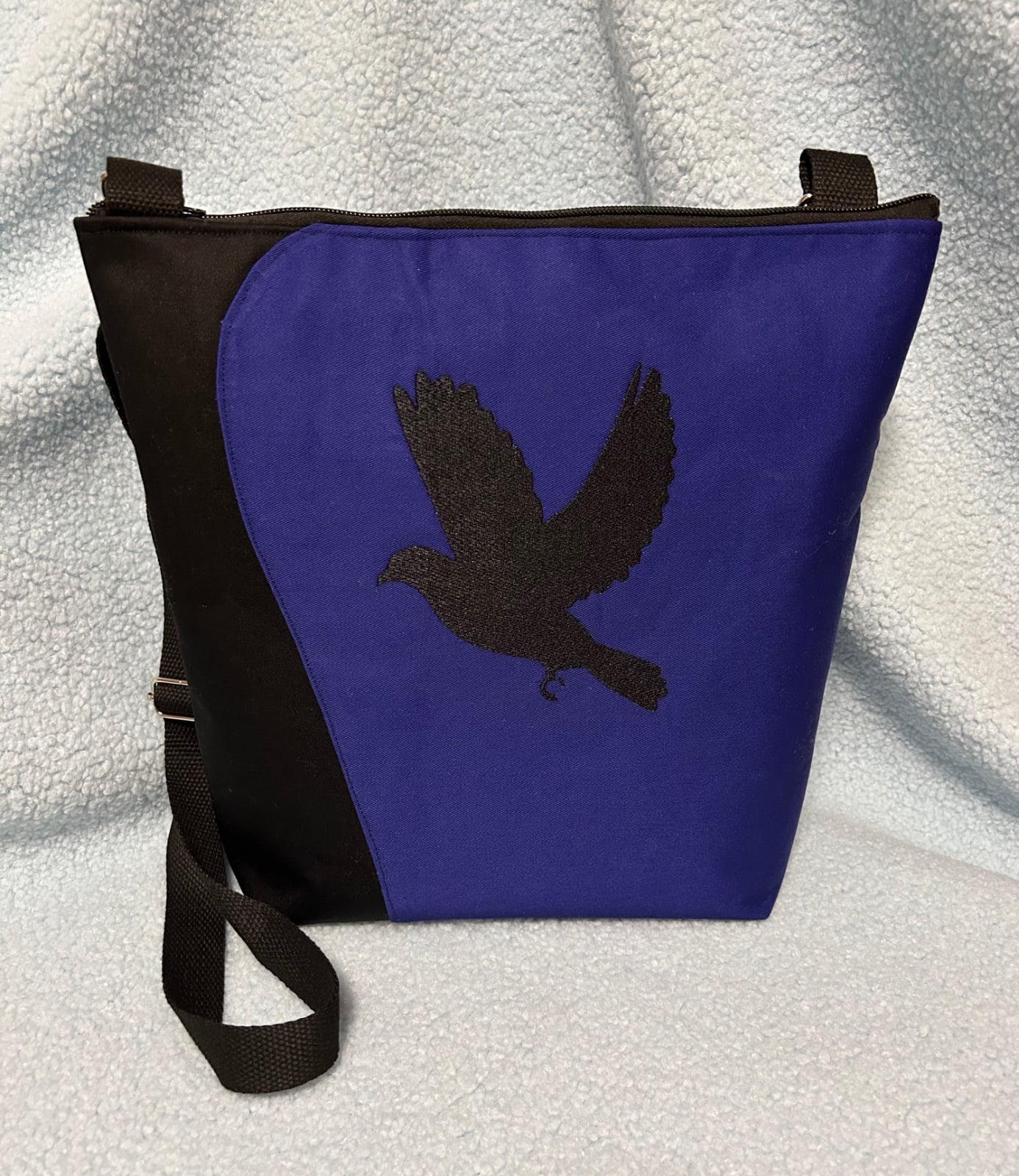 Kobalt/zwarte schoudertas geborduurd met een vogel