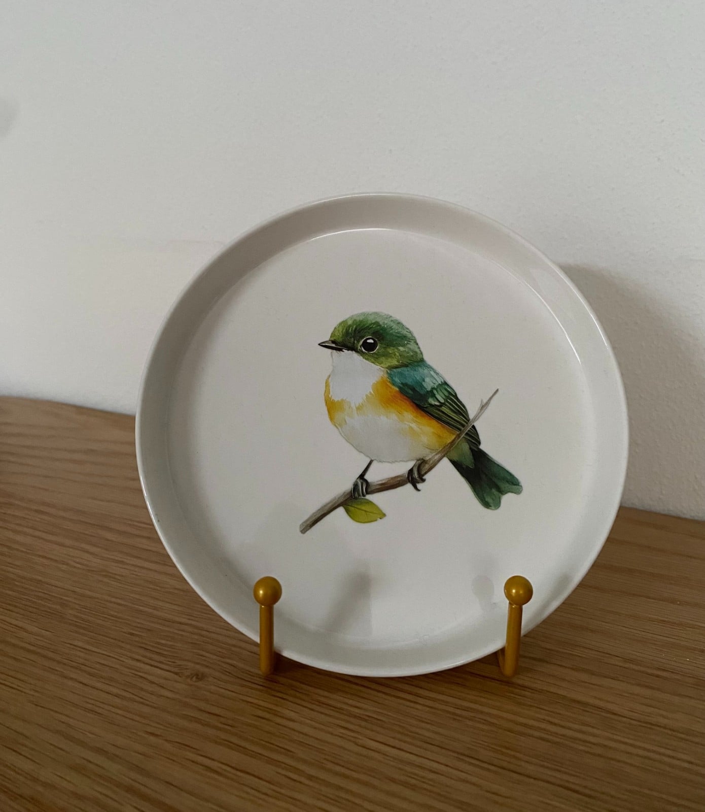 Vogel op een rond bordje met standaard.