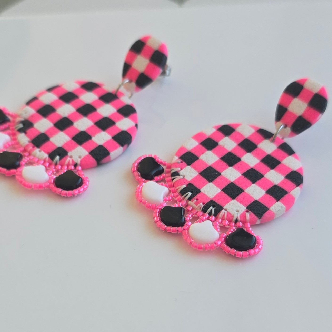 Handgemaakte neon roze, zwart, witte oorbellen van polymeerklei en kralen | Ronde retro hanger