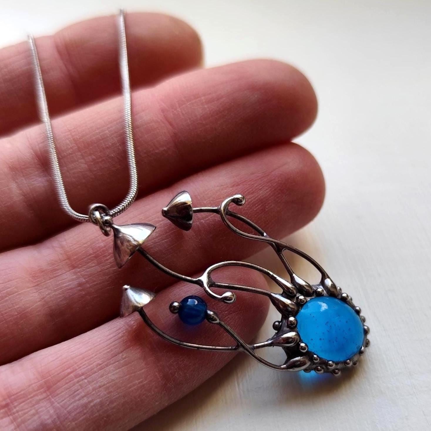 Handgemaakte paddenstoelenketting met blauw glas en zilverkleurig kop… - 142029 Handgemaakte paddenstoelenketting met blauw glas en zilverkleurig koper