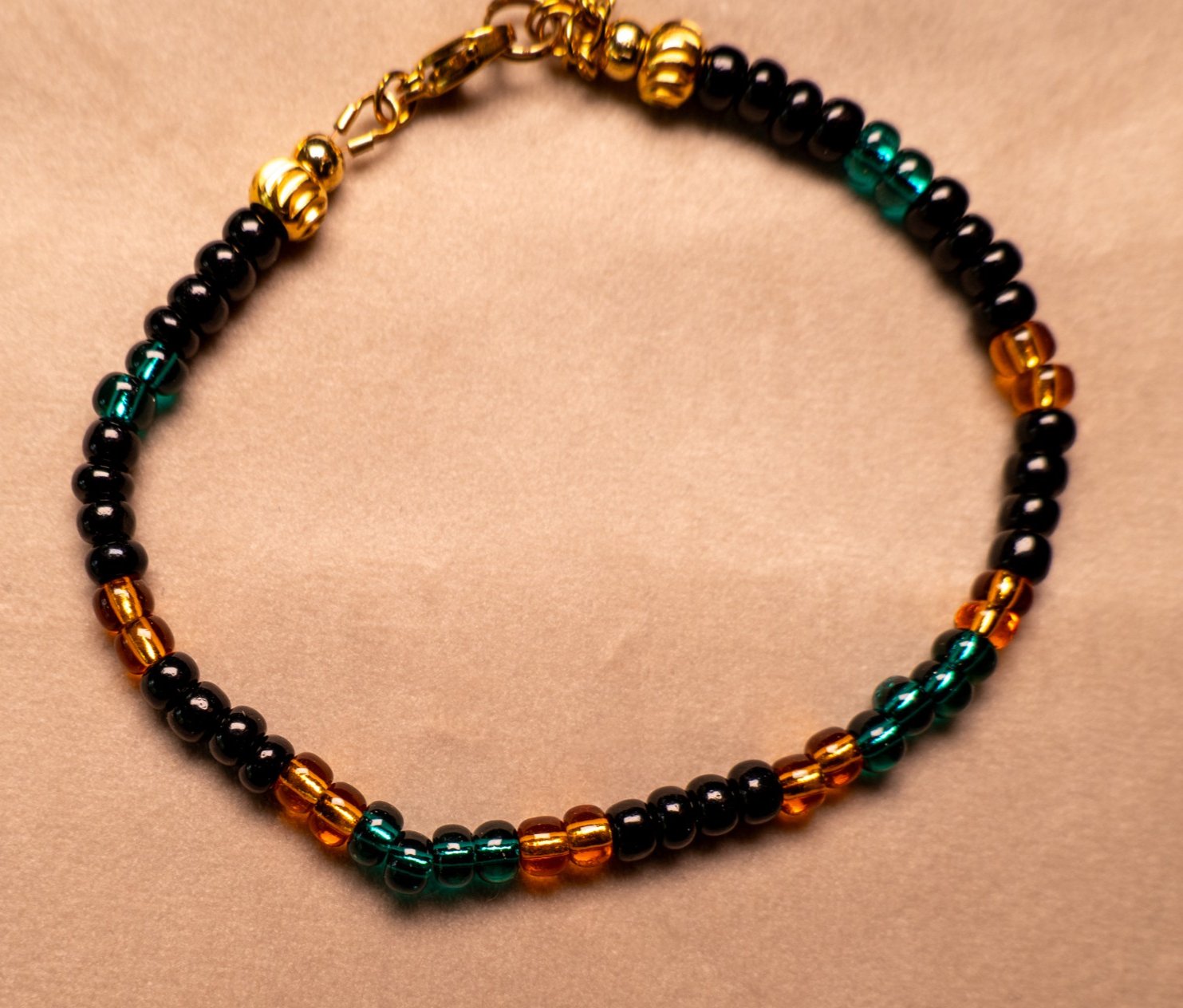 Armband van rocailles in oranje, zwart en donkergroen