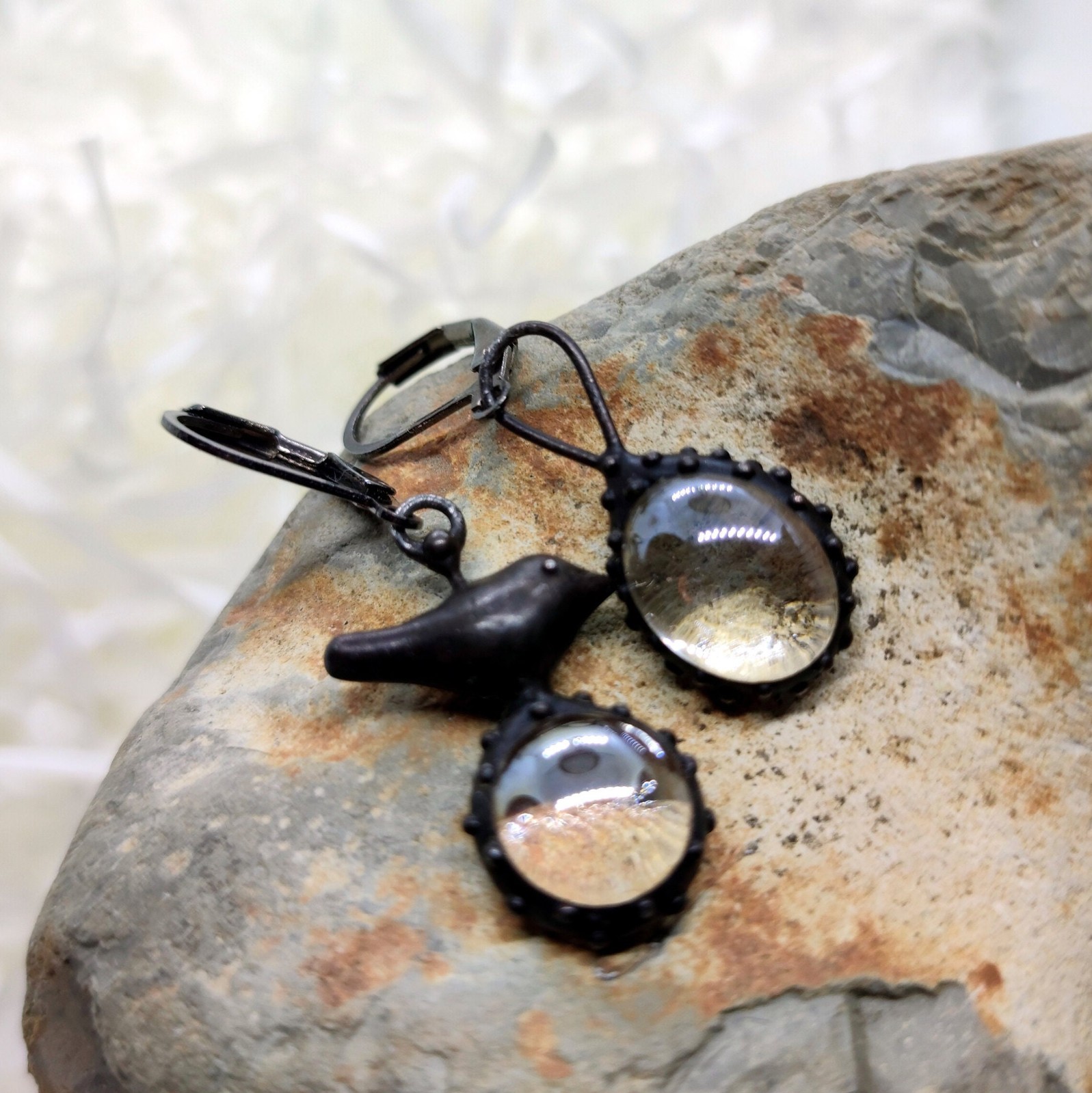 Asymmetrische handgemaakte vogeloorbellen met transparant glas en zwa… - 144821 Asymmetrische handgemaakte vogeloorbellen met transparant glas en zwart gepatineerd koper