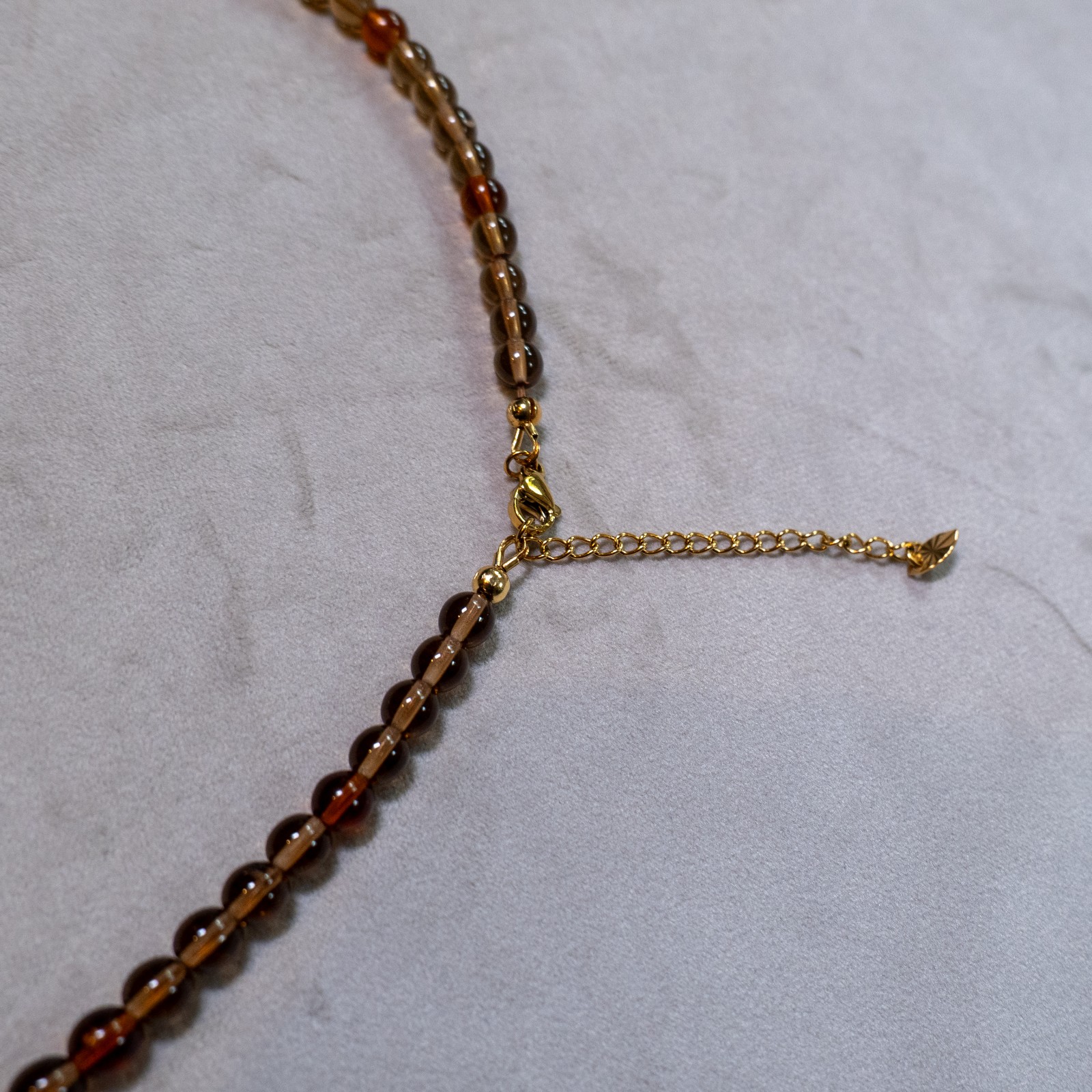 Ketting met antiek koperkleurig ornament, hart en amberkleurige facetkralen