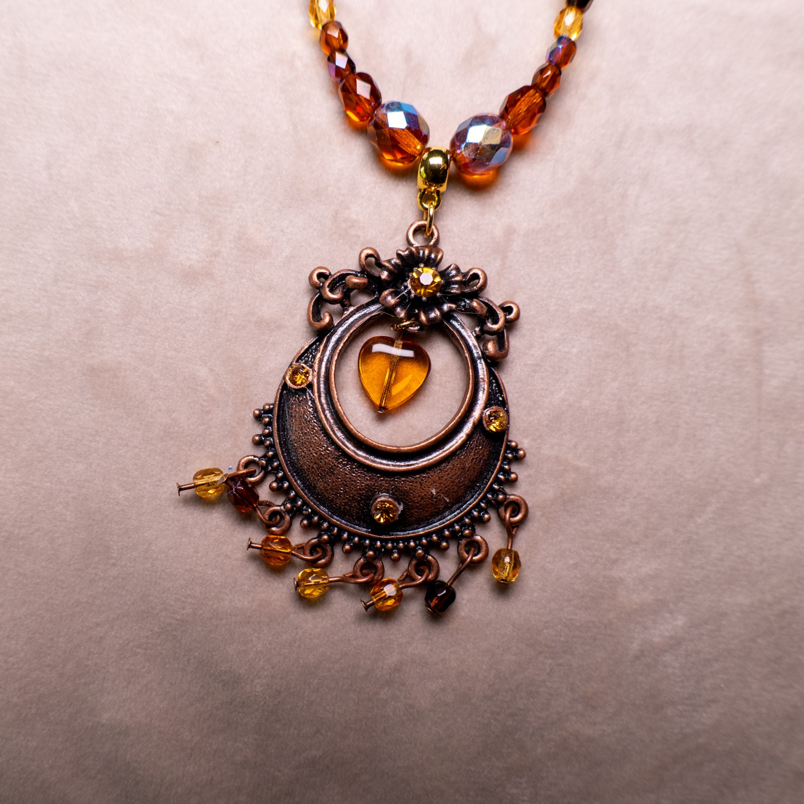 Ketting met antiek koperkleurig ornament, hart en amberkleurige facetkralen