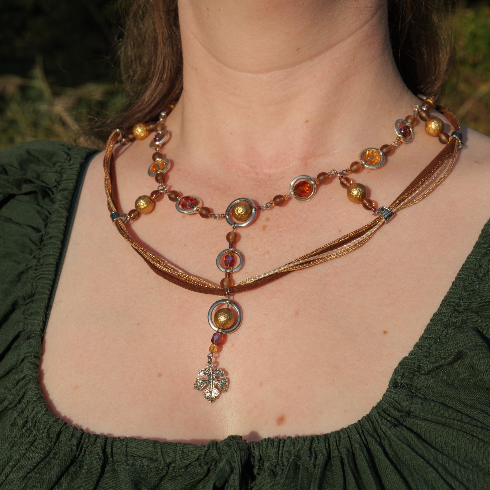 Ketting met blad-hanger, bruin lint en goudkleurige kralen