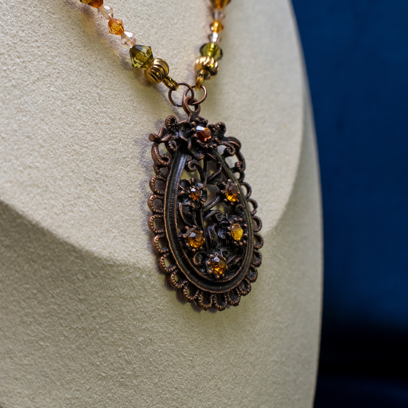 Ketting met bloemenornament in antiek koper en amberkleurige kralen