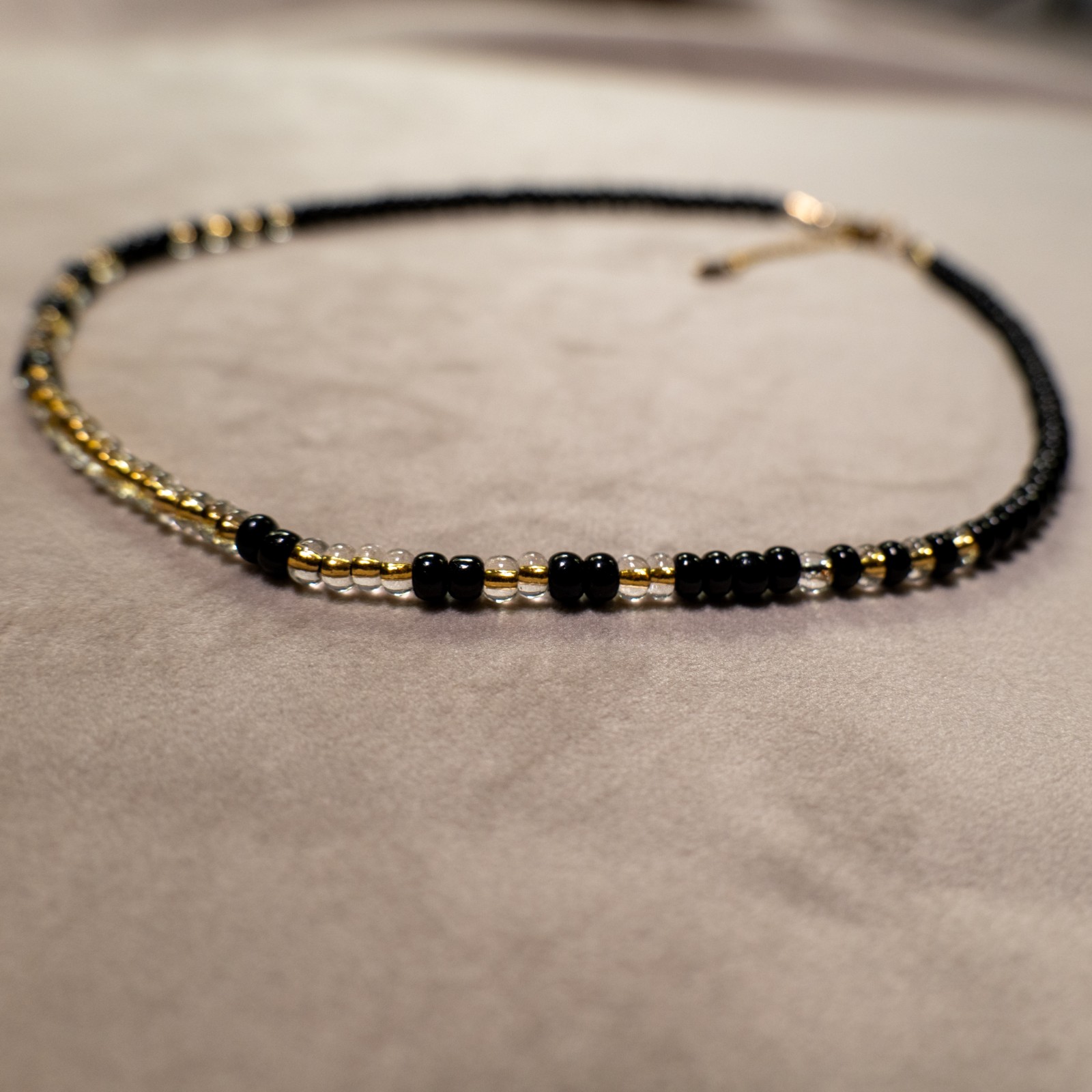 Ketting met zwarte rocailles en transparante kralen met gele kern