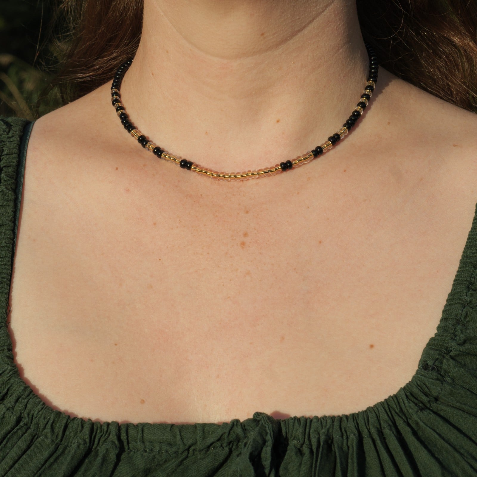 Ketting met zwarte rocailles en transparante kralen met gele kern