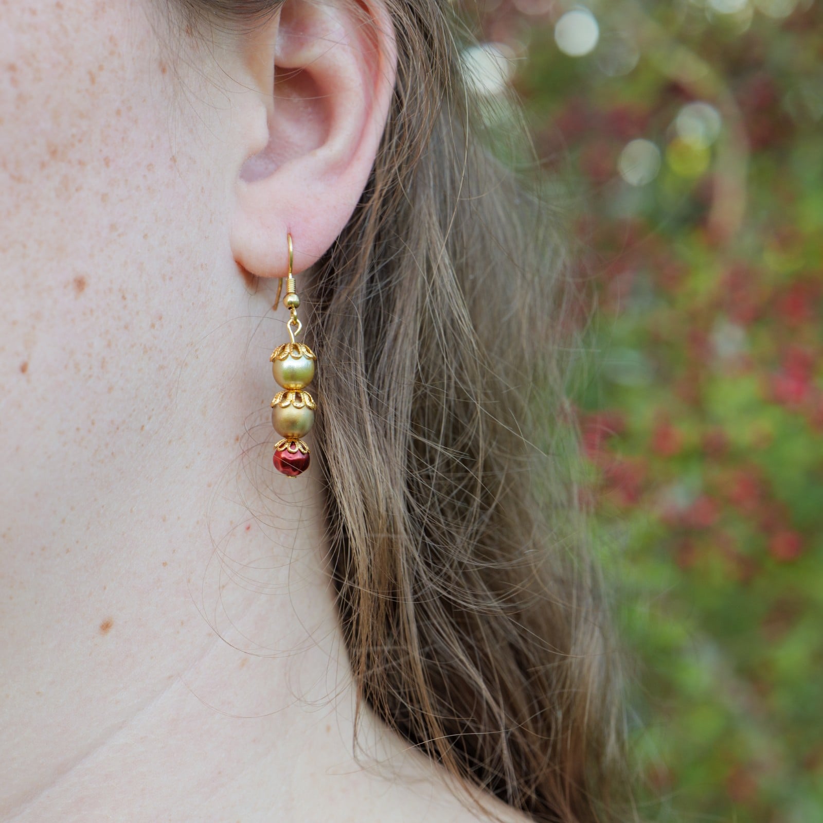Oorbellen met bronskleurige en granaatappelrode kralen