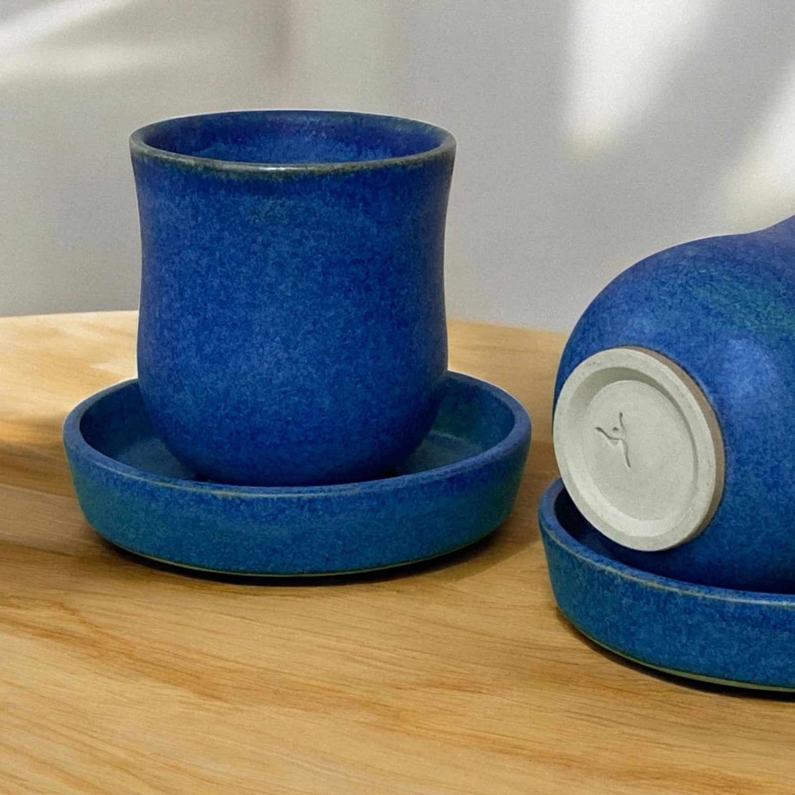 Handgemaakt keramiek, theemokken met schoteltje diepblauw gekleurd