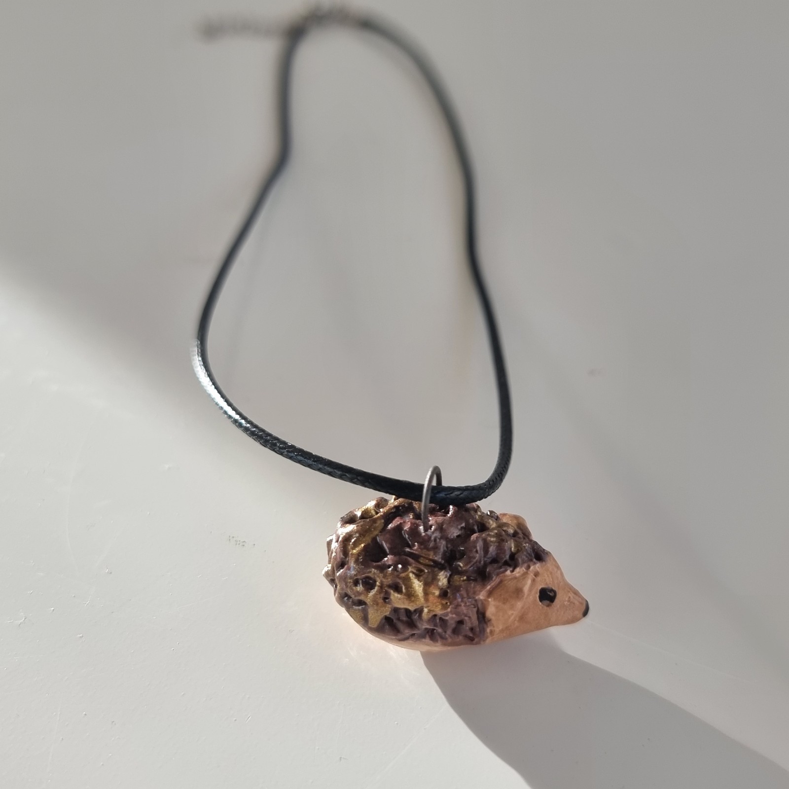 Halsketting met een egeltje van keramiek. Aan een waxkoordje. - 101159 Halsketting met een egeltje van keramiek. Aan een waxkoordje.