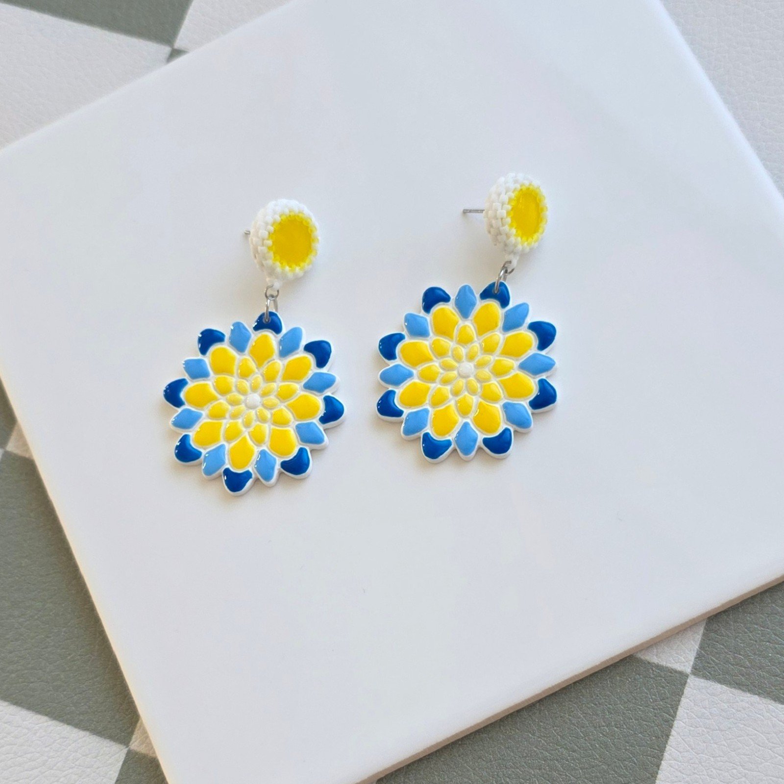 Handgemaakte geel, blauw en witte oorbellen van polymeerklei en krale… - 102167 Handgemaakte geel, blauw en witte oorbellen van polymeerklei en kralen | Bloem