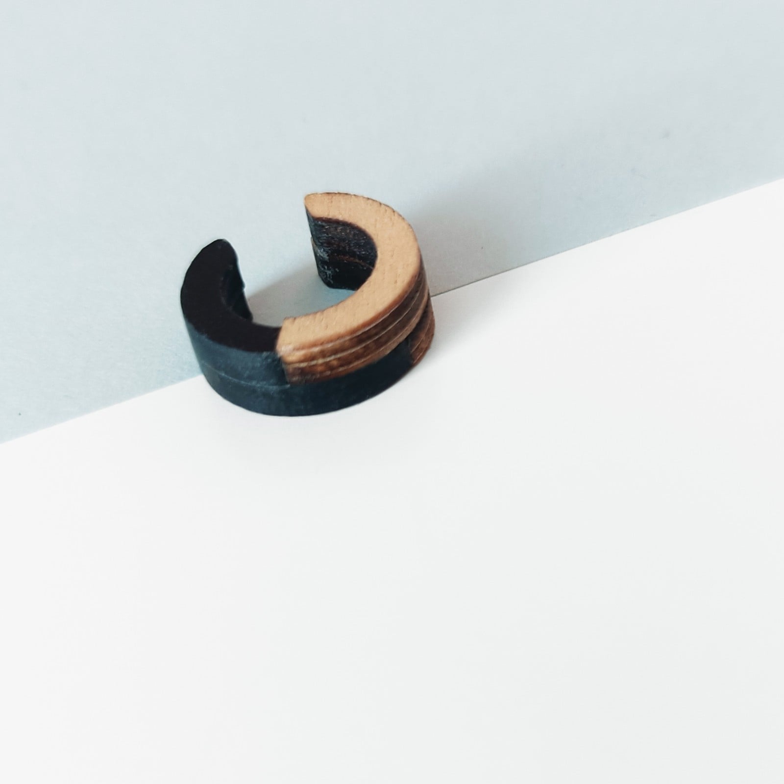 Hout met zwart kunststof geometrische cuff oorbel