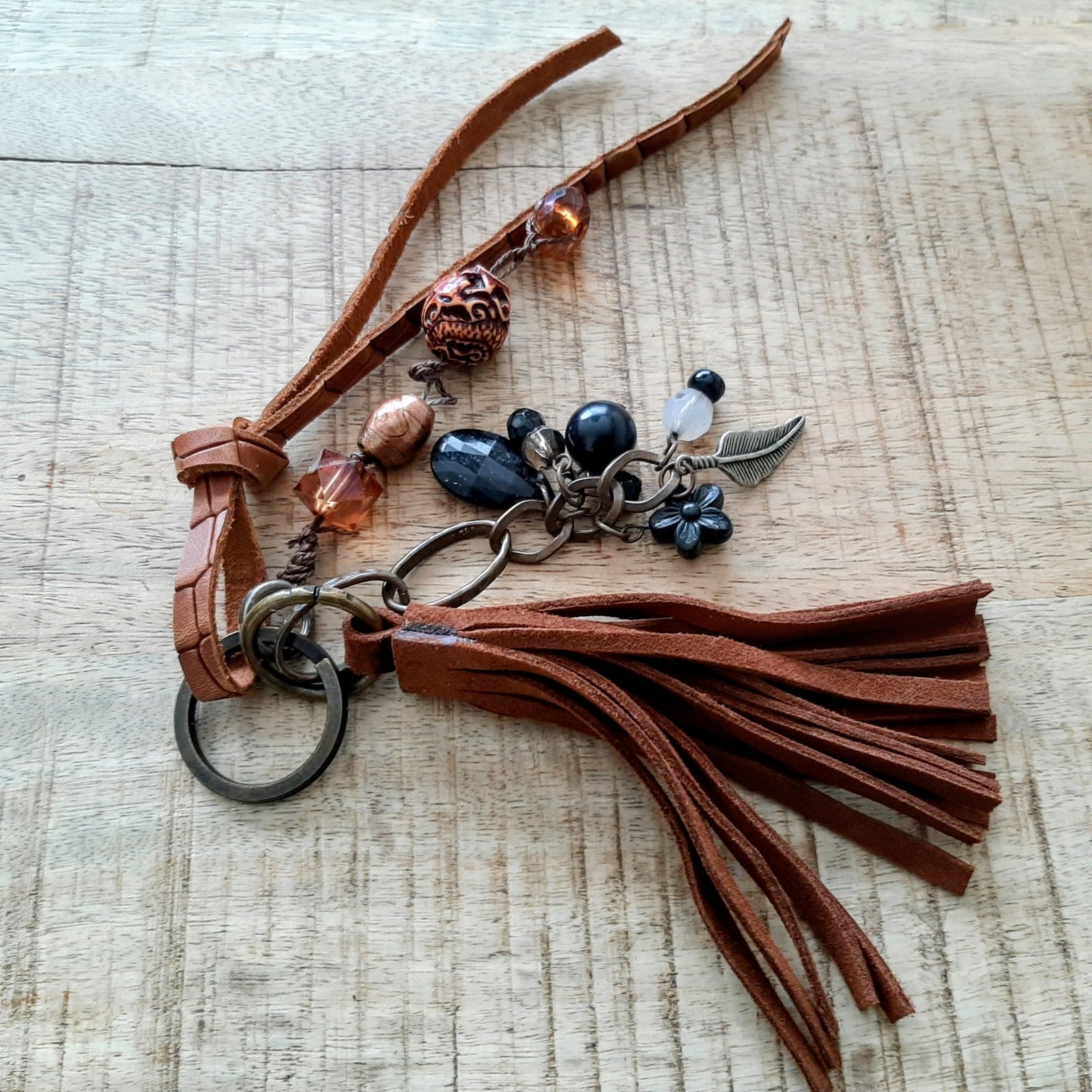 Sleutelhanger, handgemaakt van kralen en leren flos hangen samen aan een sleutelring.