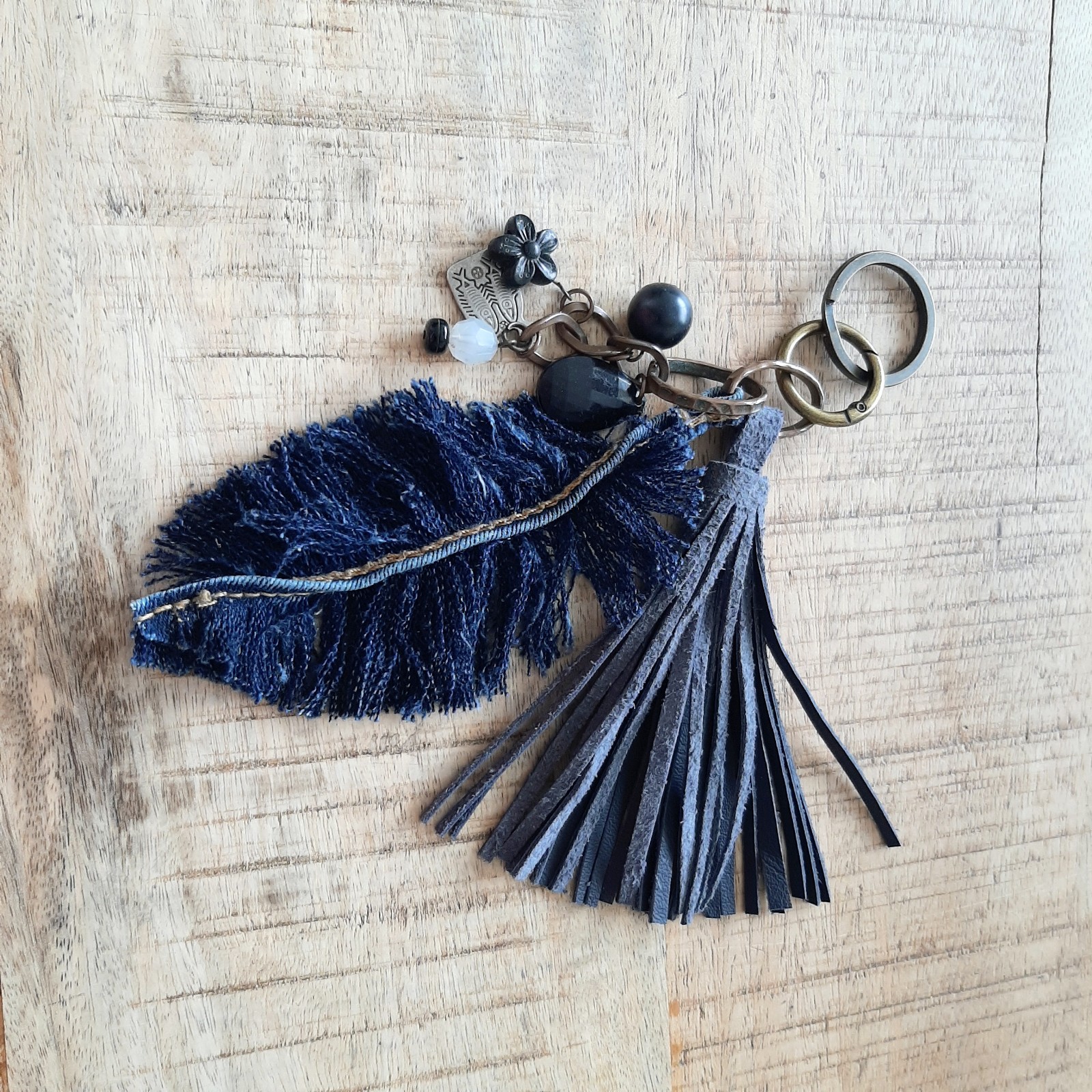sleutelhanger, handgemaakt met leren kwart, denim veer en kralen. Ook te gebruiken als Bagcharm voor aan je tas