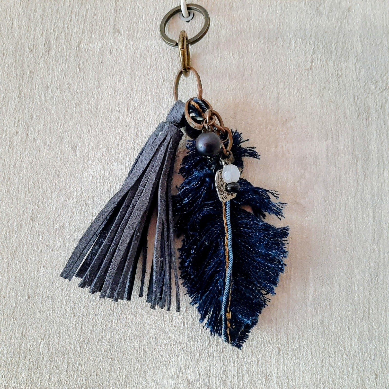 sleutelhanger, handgemaakt met leren kwart, denim veer en kralen. Ook te gebruiken als Bagcharm voor aan je tas