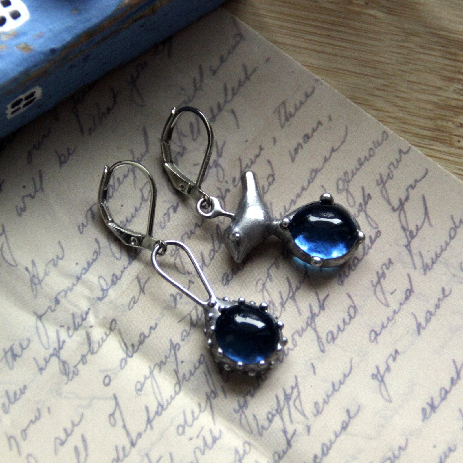 Asymmetrische handgemaakte vogeloorbellen met blauw glas en zilverkle… - 143149 Asymmetrische handgemaakte vogeloorbellen met blauw glas en zilverkleurig koper