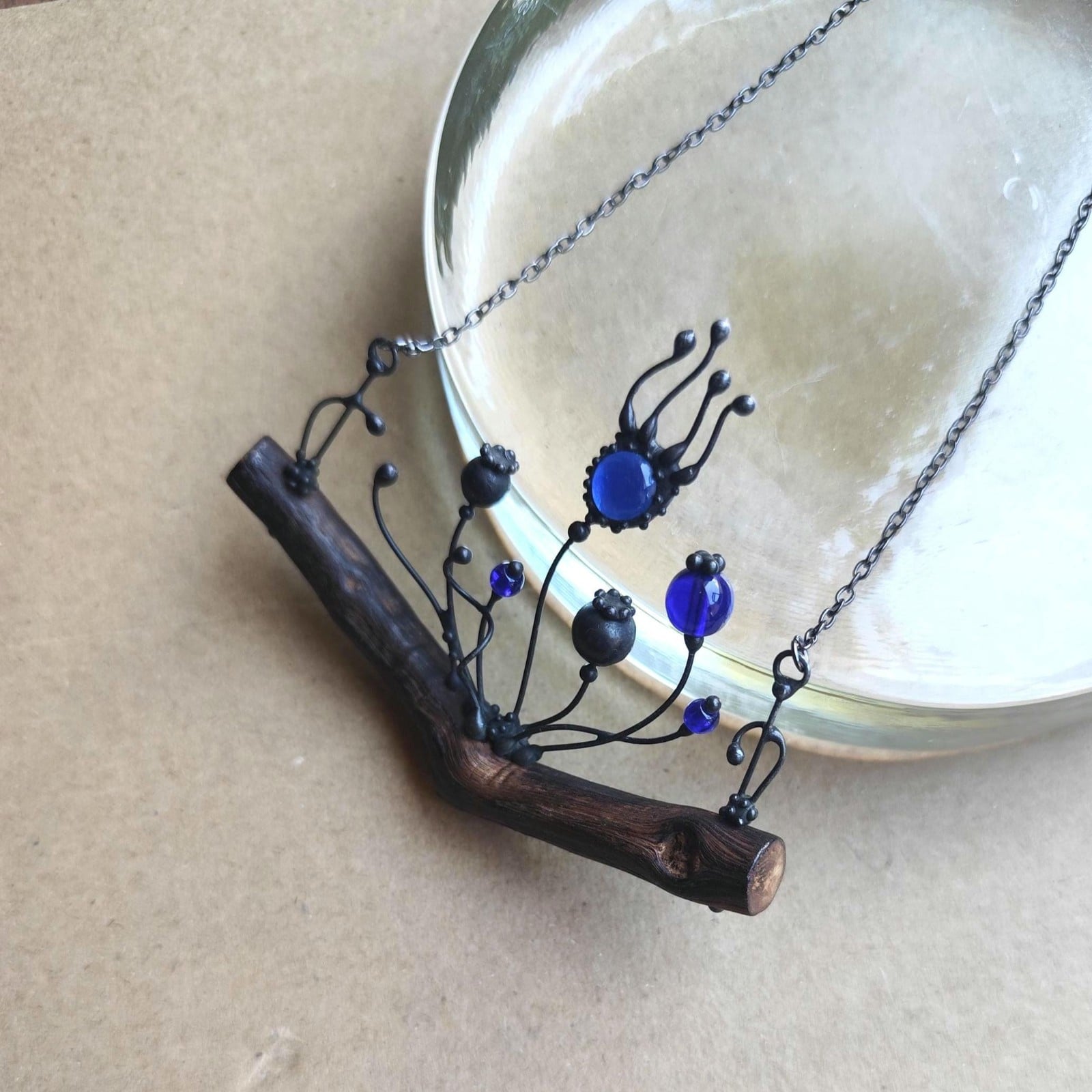 Handgemaakte klaprozenketting met blauw glas en zwart gepatineerd koper
