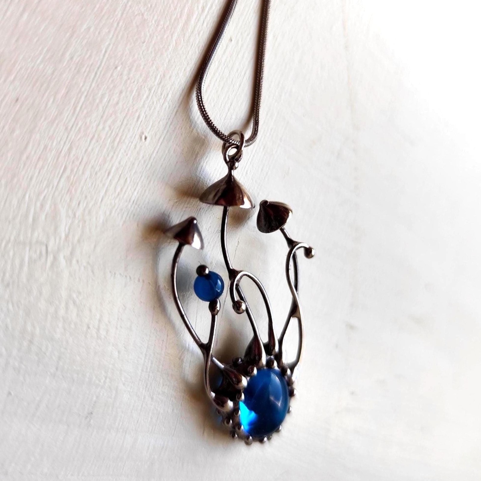 Handgemaakte paddenstoelenketting met blauw glas en zilverkleurig kop… - 142030 Handgemaakte paddenstoelenketting met blauw glas en zilverkleurig koper
