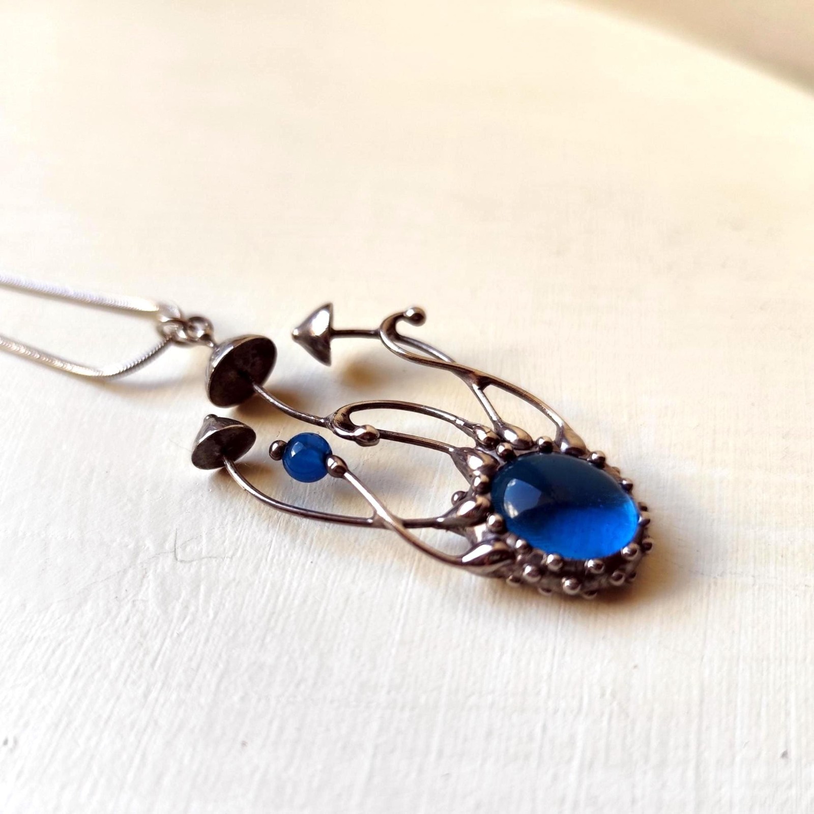 Handgemaakte paddenstoelenketting met blauw glas en zilverkleurig kop… - 142034 Handgemaakte paddenstoelenketting met blauw glas en zilverkleurig koper
