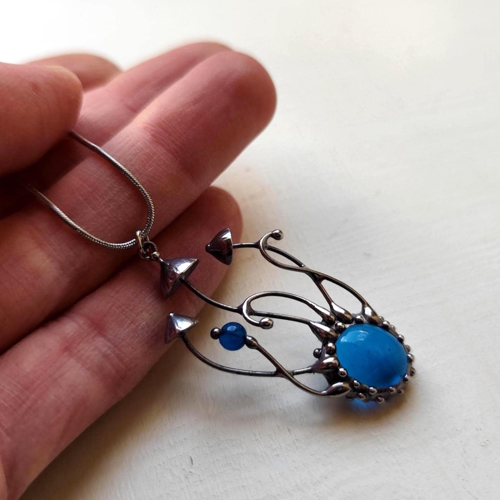 Handgemaakte paddenstoelenketting met blauw glas en zilverkleurig kop… - 142035 Handgemaakte paddenstoelenketting met blauw glas en zilverkleurig koper
