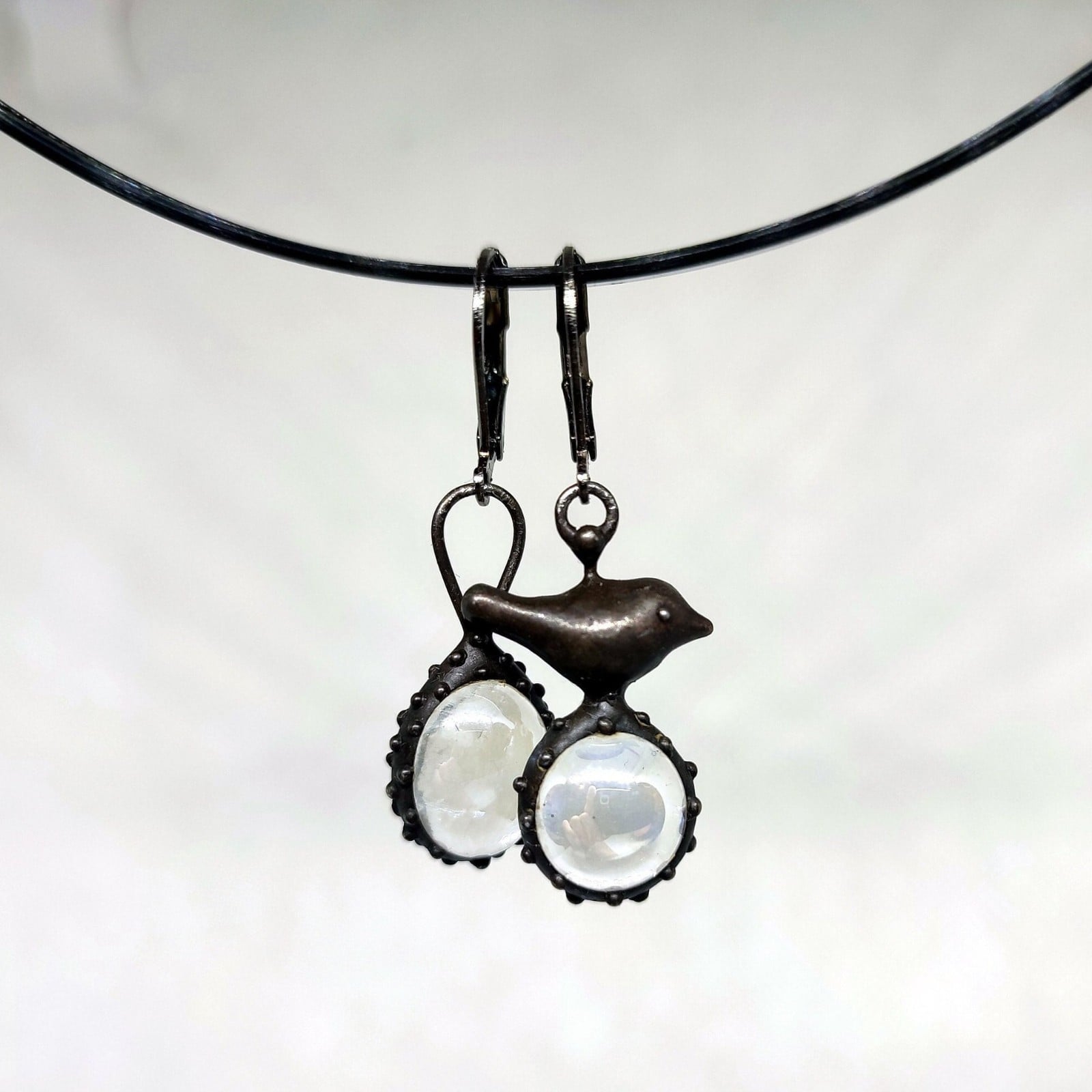 Asymmetrische handgemaakte vogeloorbellen met transparant glas en zwa… - 144819 Asymmetrische handgemaakte vogeloorbellen met transparant glas en zwart gepatineerd koper