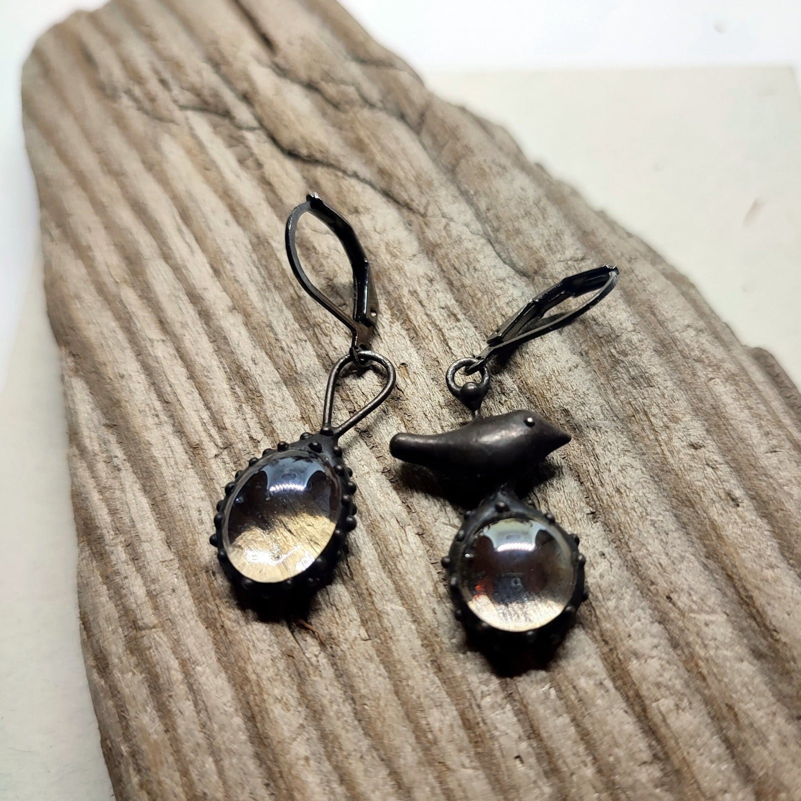 Asymmetrische handgemaakte vogeloorbellen met transparant glas en zwa… - 144823 Asymmetrische handgemaakte vogeloorbellen met transparant glas en zwart gepatineerd koper