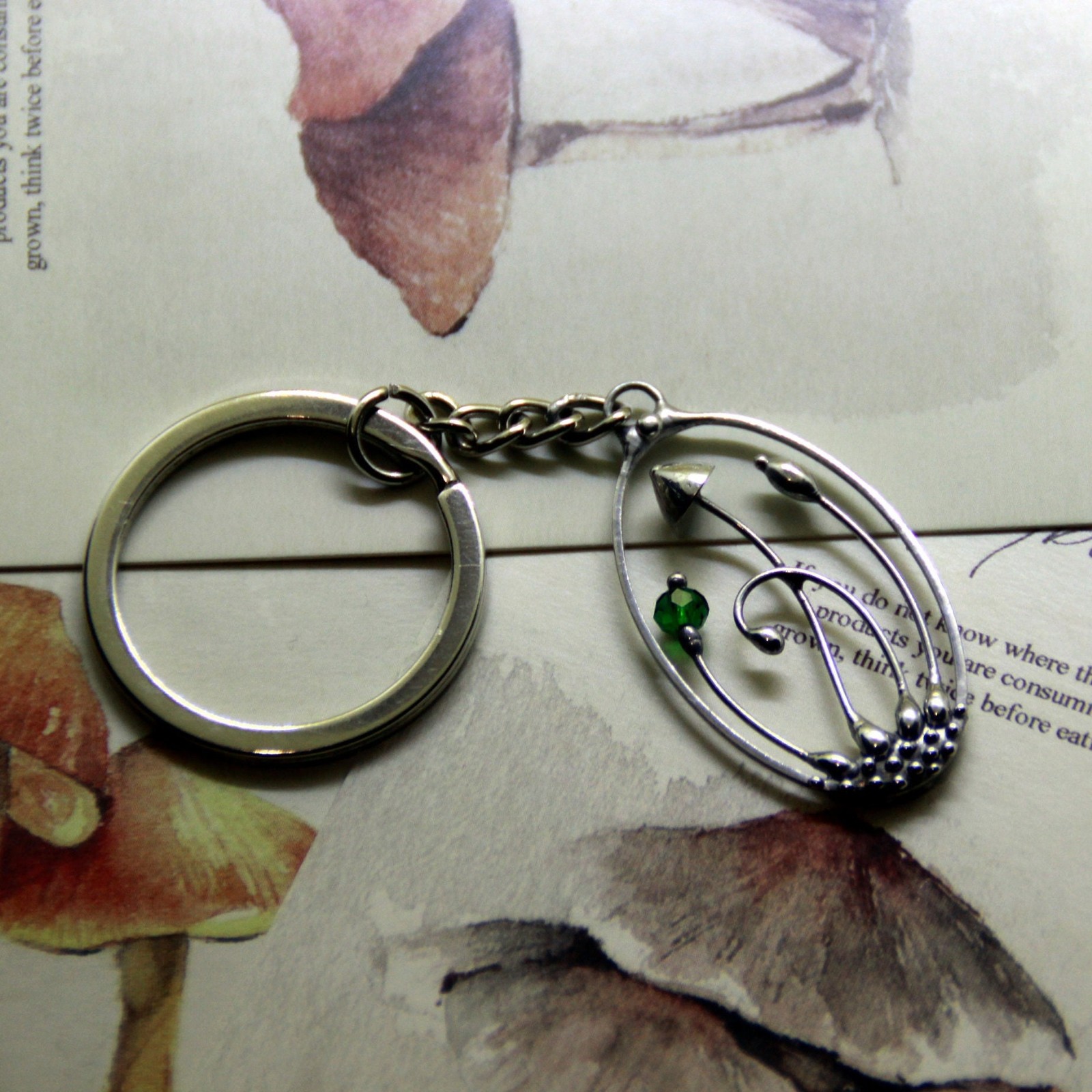 Handgemaakte paddenstoelensleutelhanger met groen glas en zilverkleur… - 145117 Handgemaakte paddenstoelensleutelhanger met groen glas en zilverkleurig koper