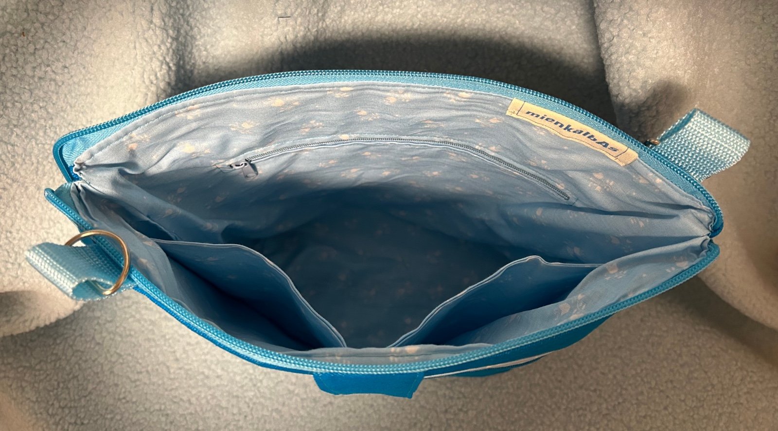 Schoudertas in aqua kleur met geborduurde fantasievogel.