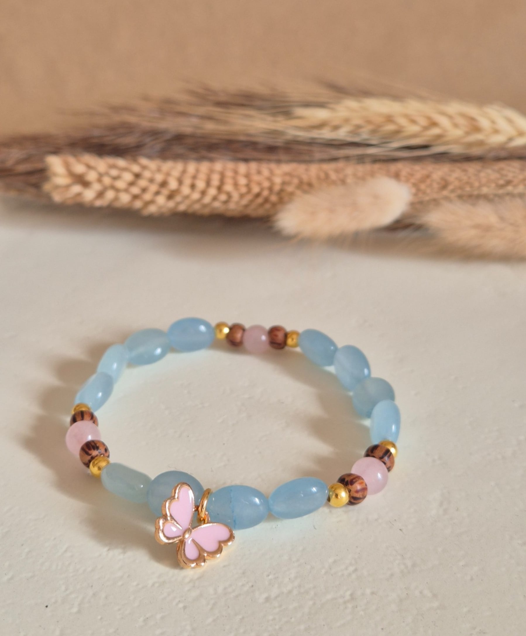 Vrolijke roze/gouden vlinder armband